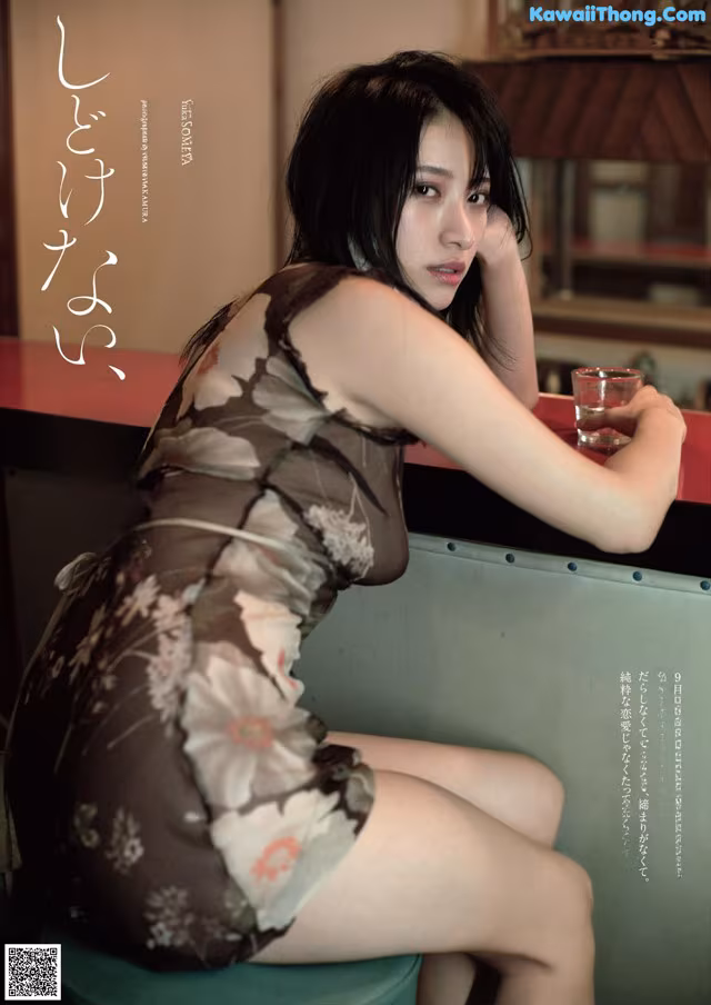 A woman sitting at a table with a glass of water.