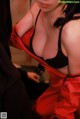 A woman in a red and black lingerie posing for a picture.