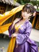 A woman in a purple and yellow hanbok posing for a picture.