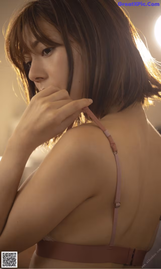 A woman in a pink bra is posing for a picture.