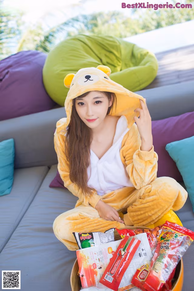 A woman in a bear costume sitting on a couch.