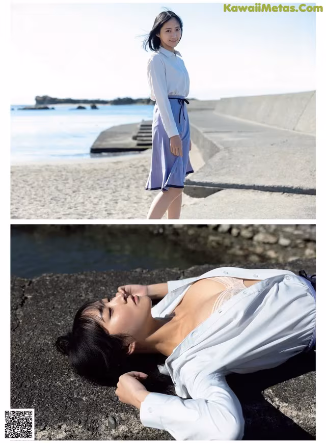 A woman laying on the ground next to the ocean.