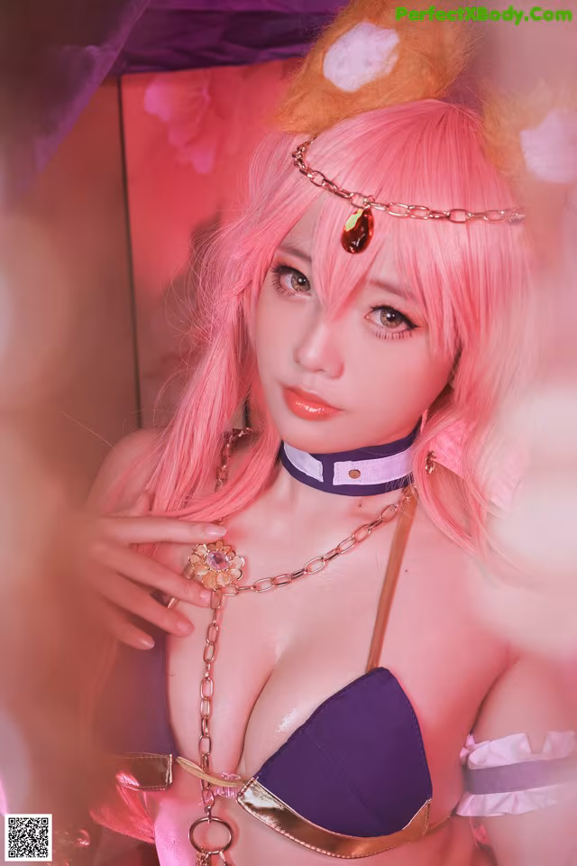 A woman with pink hair wearing a purple bikini.