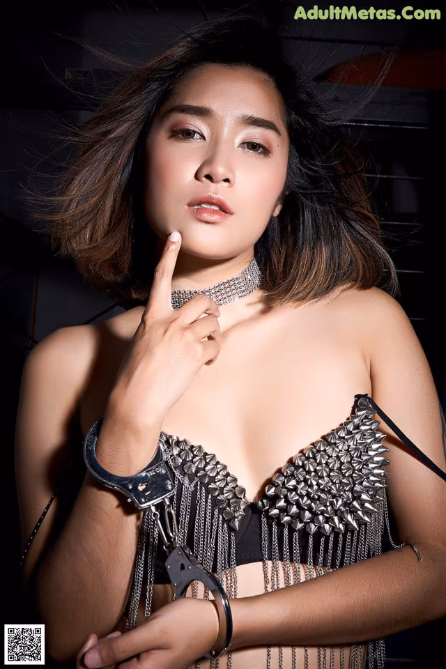 A woman in a black bra top holding a pair of handcuffs.