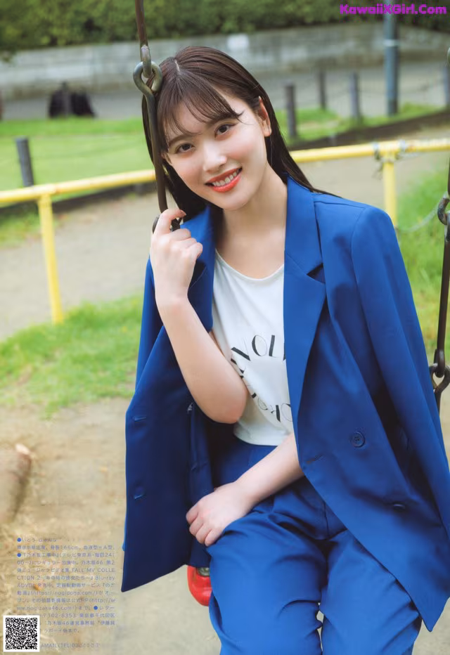 A woman in a blue suit sitting on a swing.