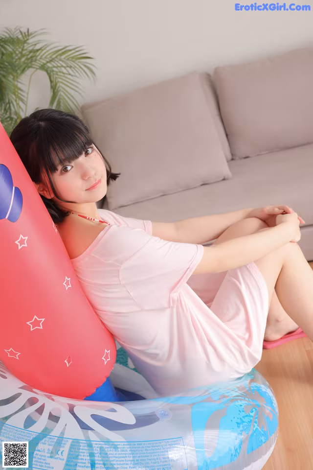 A woman sitting on an inflatable chair in a living room.