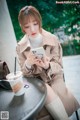 A woman sitting at a table looking at her phone.