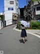 A woman walking down a street holding an umbrella.